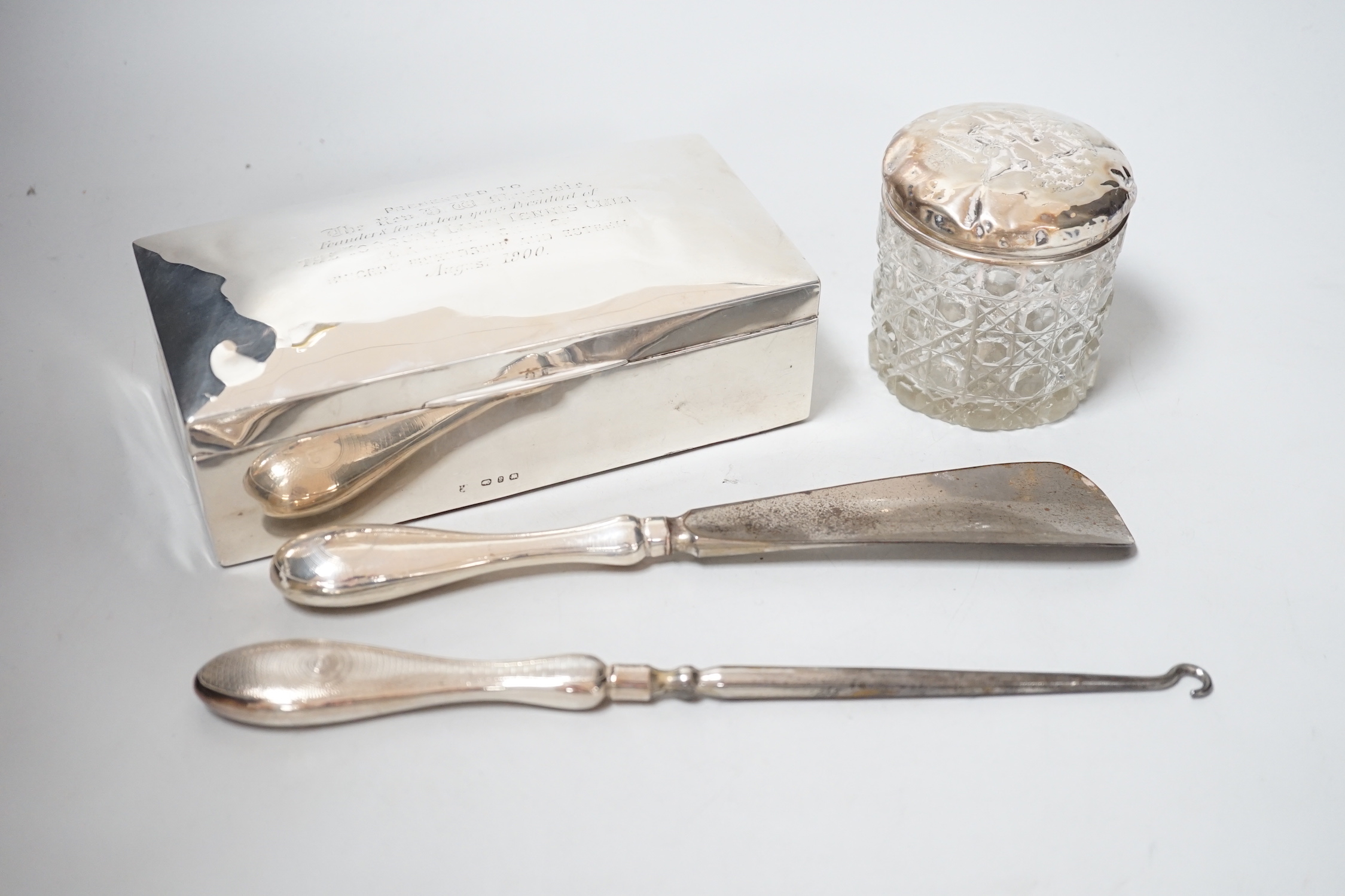A late Victorian silver mounted cigarette box, 17.8cm, a silver handle show horn and button hook and a silver mounted glass toilet jar.